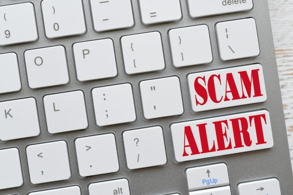 The words "Scam Alert" on a keyboard representing scams targeting Freelancers obtaining a visa in Dubai and free zones including Ajman free zone