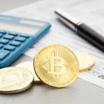 Some bitcoin next to a calculator when doing crypto tax