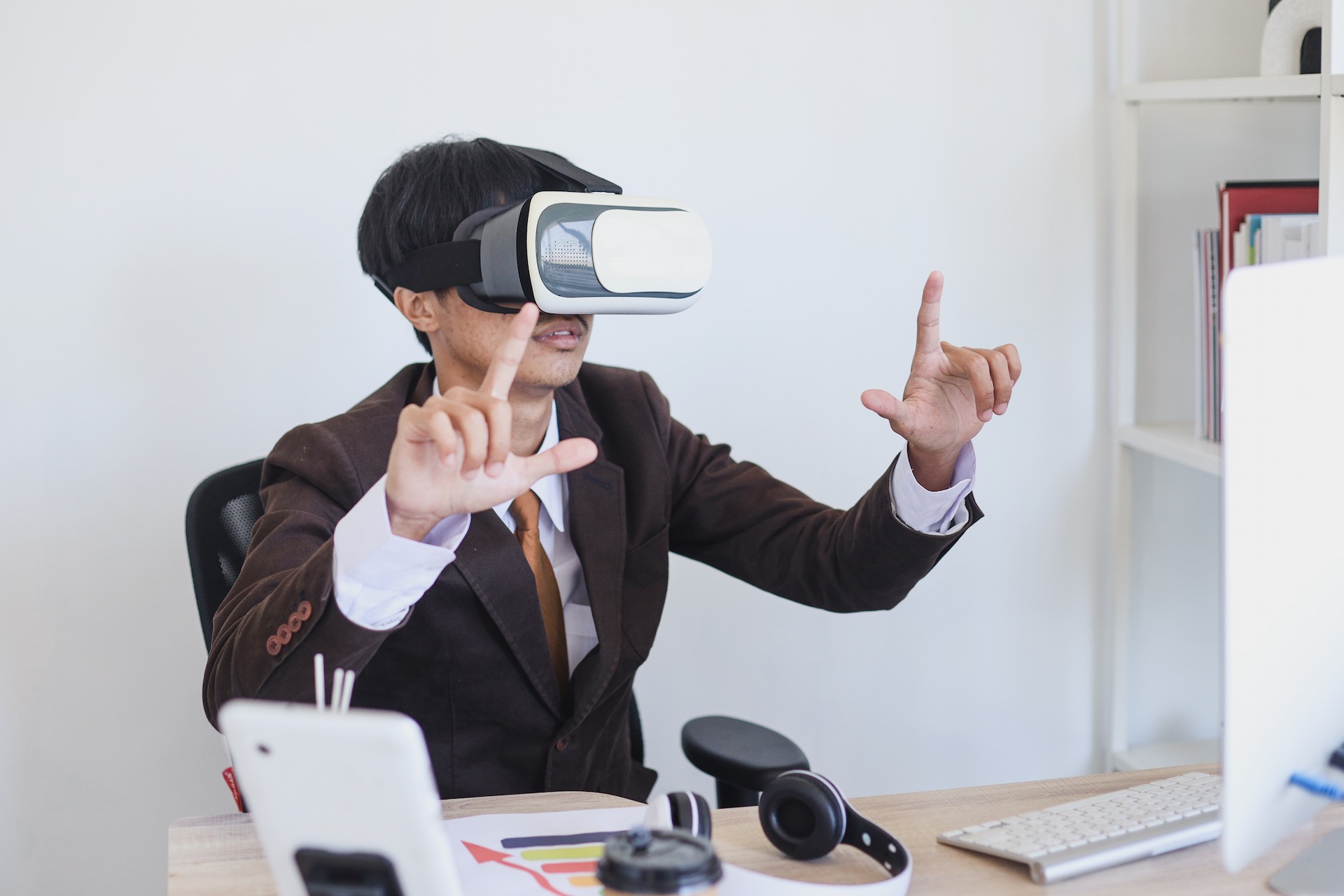 Image of a man using a VR headset whilst working.