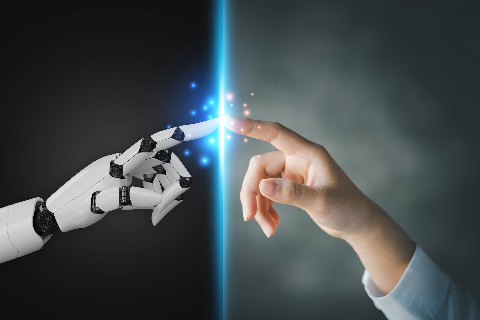 A stock photo of a robot hand and a human hand touching at the fingertips